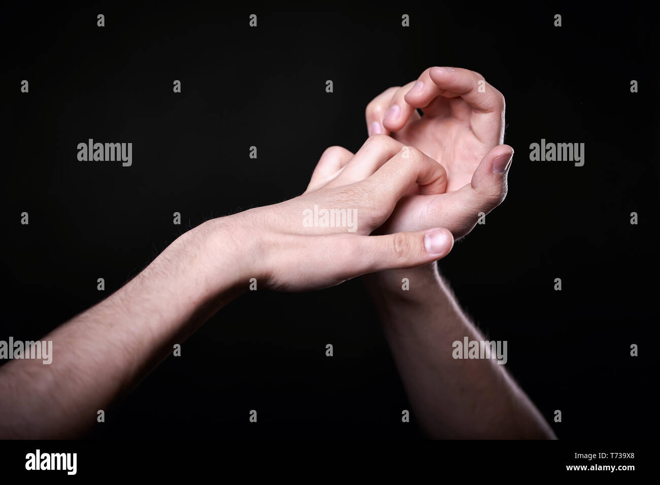 two beautiful man's hands in the dark Stock Photo