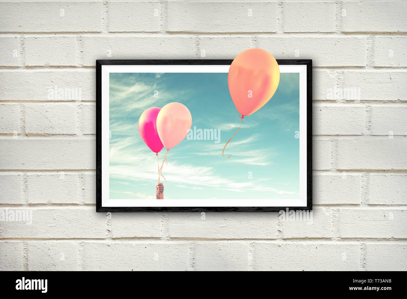 Frame with air balloons on a white brick wall, thinking outside the box concept Stock Photo