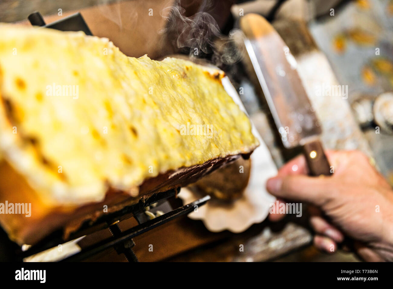 Raclette on the raclette grill is already grilled and spread with a