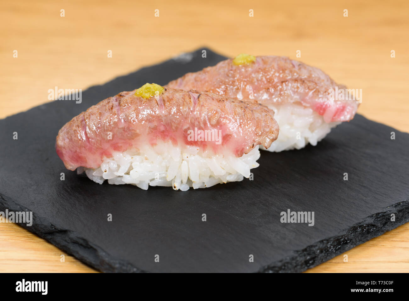 nigiri of heatburned kobe beef dressed with mustard, served on a