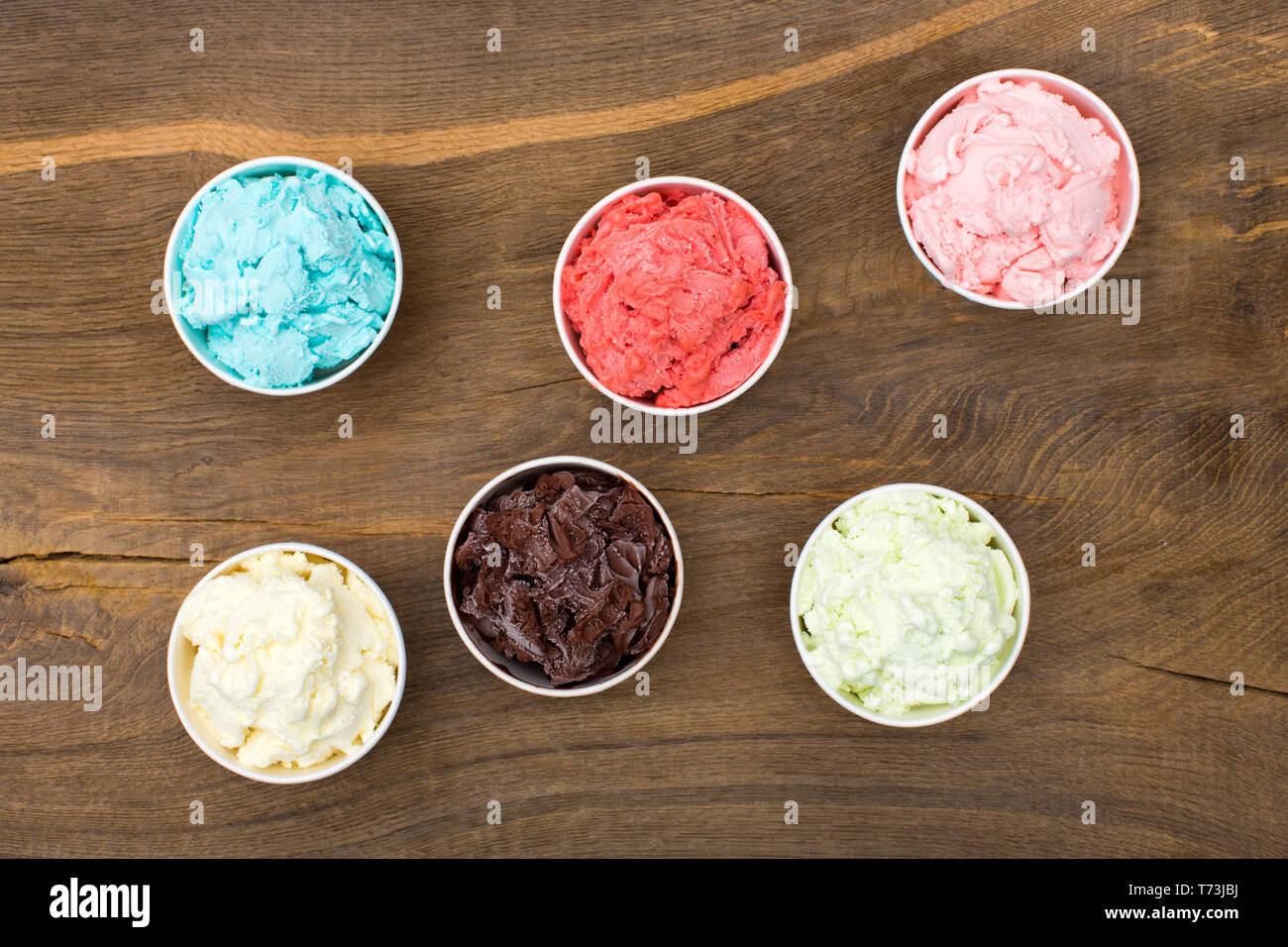 Different ice-creams on brown background. Stock Photo