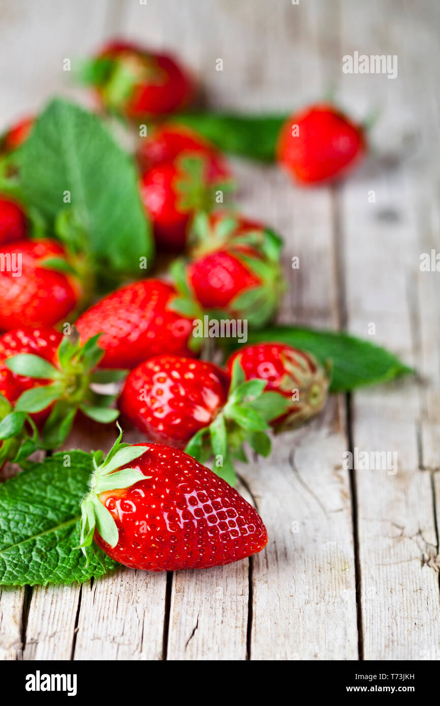 Fresh red strawberries and mint leaves on rustic wooden background ...