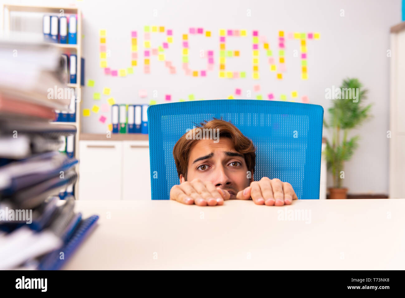 Young employee suffering from excessive work Stock Photo