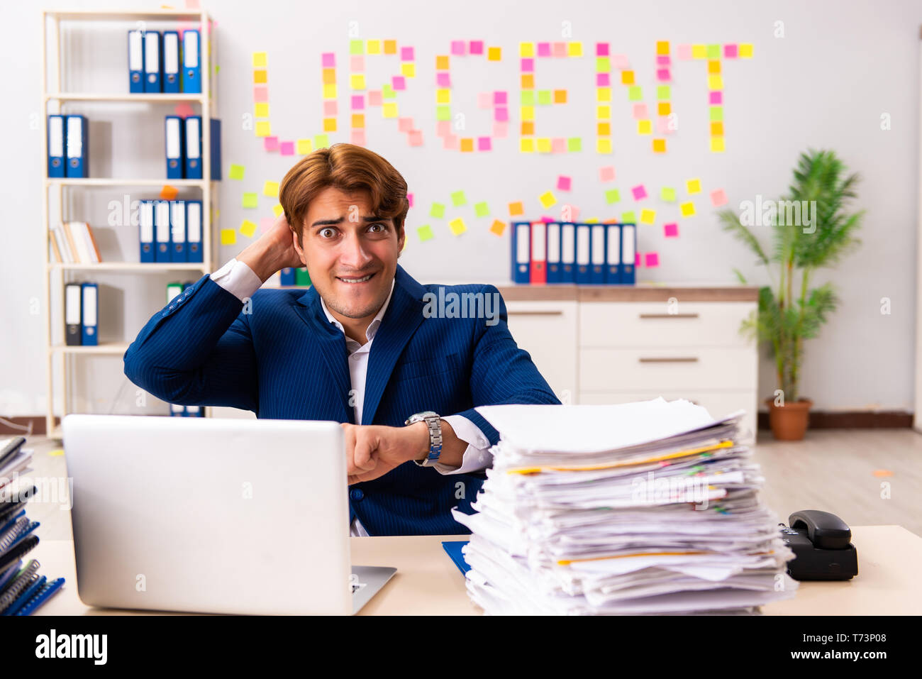 Young employee suffering from excessive work Stock Photo
