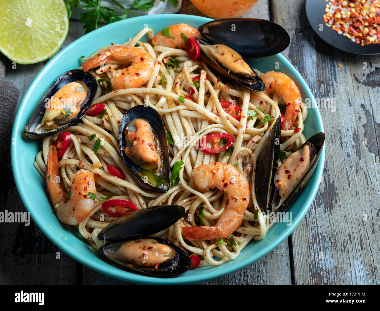 Noodles pasta with shrimp and mussels , spice , on the plate. Closeup. Stock Photo