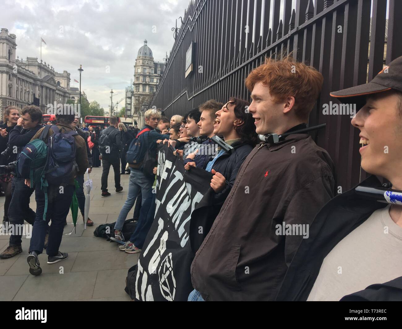Protesters from the youth wing of Extinction Rebellion tie themselves to a fence outside Parliament in London to raise awareness of climate change ahead of the EU elections. Stock Photo