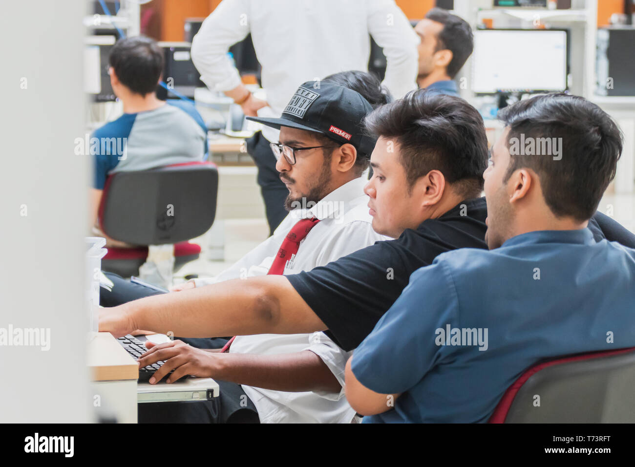 Group of Asian university computer engineering students working and discuss how to solve computer programming problems in an assignment Stock Photo