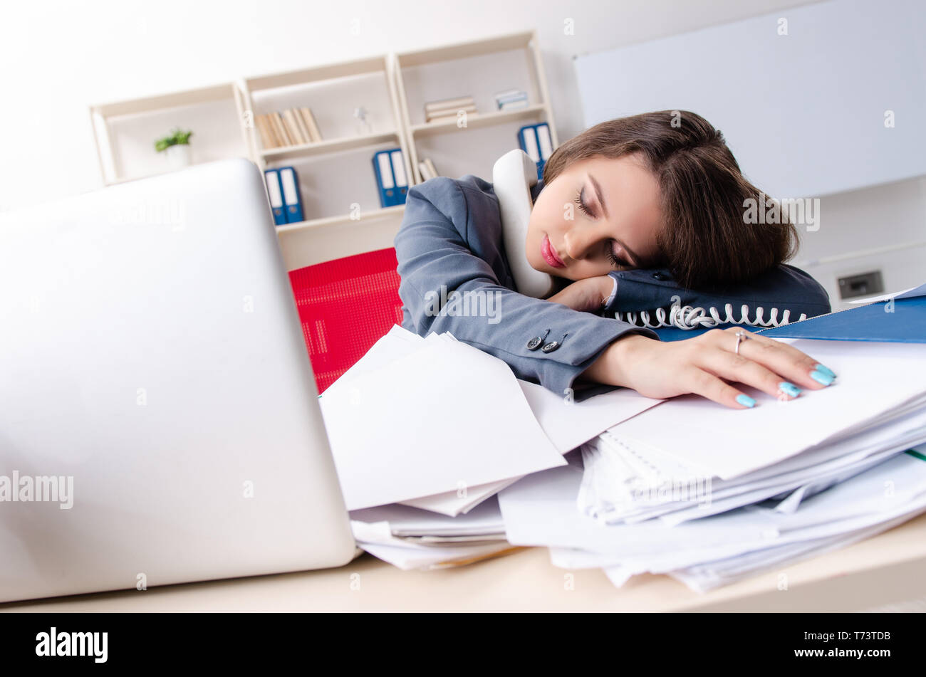 Beautiful female employee unhappy with excessive work Stock Photo