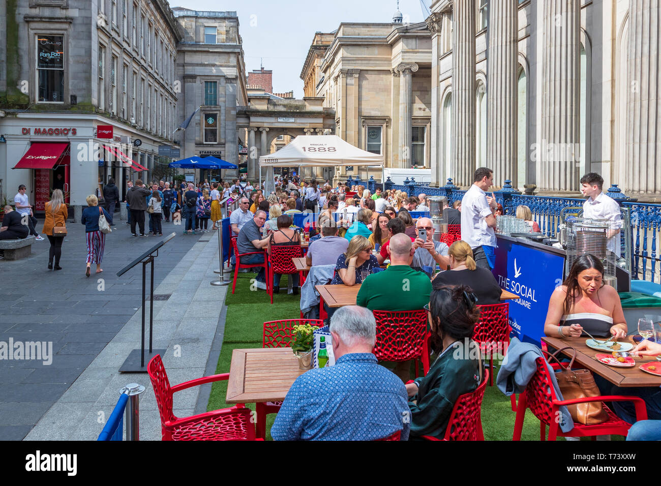 People eating at outdoor tables at a restaurant in Royal Exchange Square, Glasgow, Scotland Stock Photo