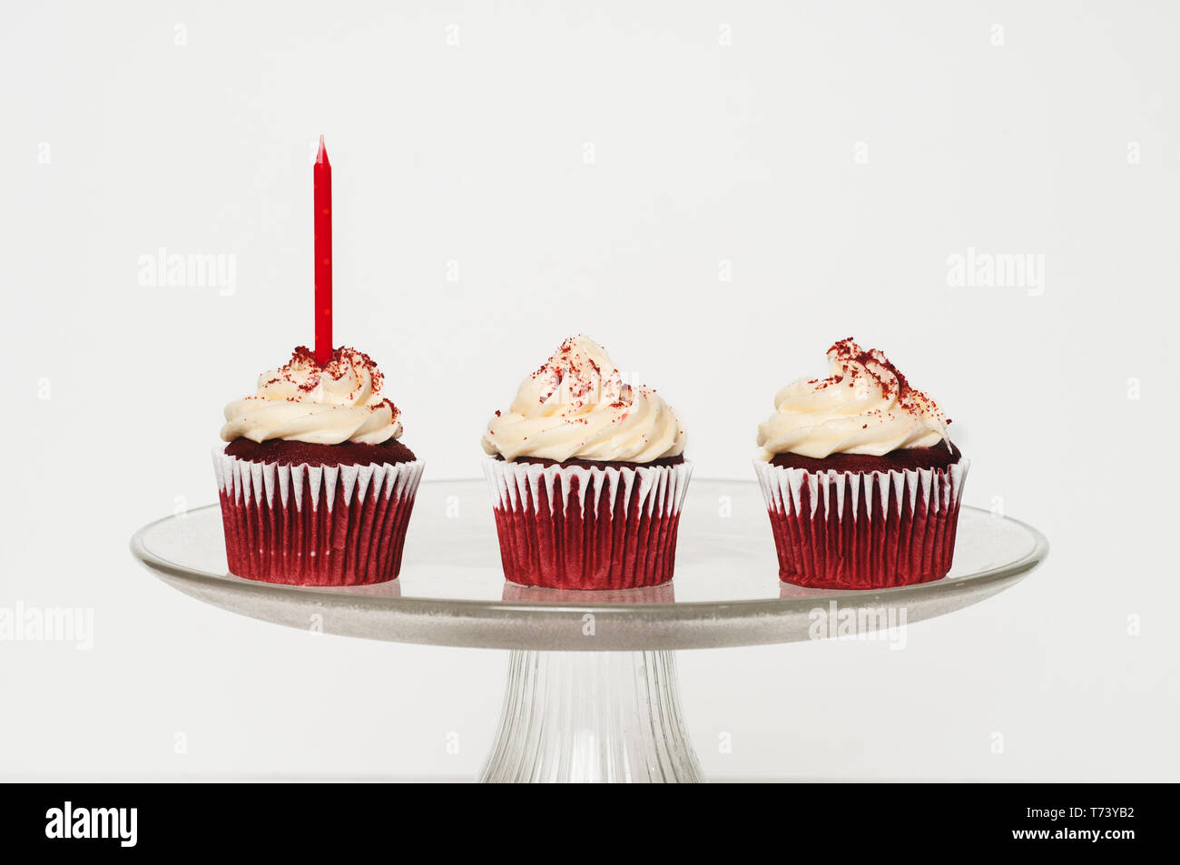 three cupcakes with frosting on a cake stand Stock Photo
