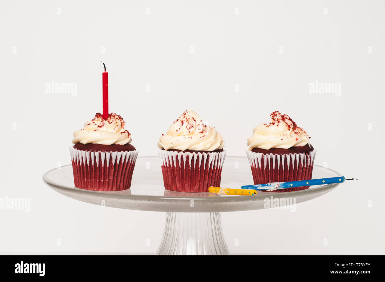 three cupcakes with frosting on a cake stand Stock Photo