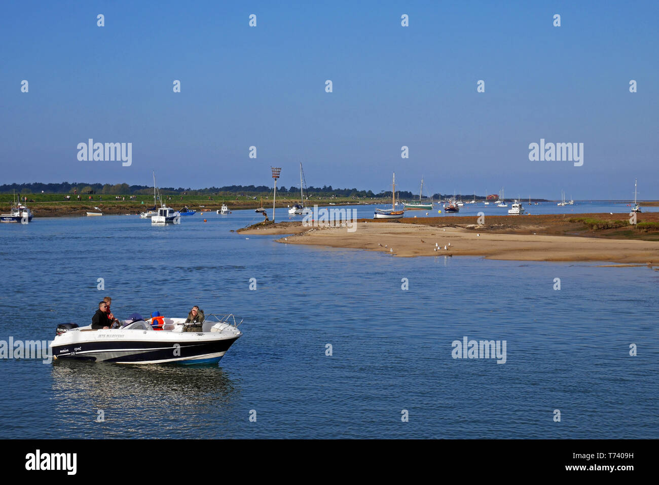 The creak with it boats leading into harbour town of Wells-next-the-Sea in North Norfolk, England, UK Stock Photo