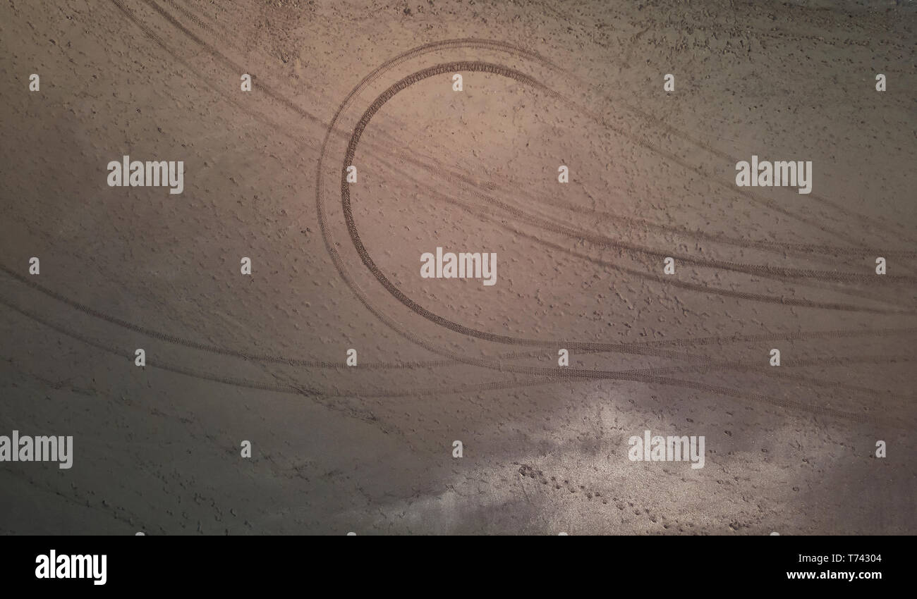 Car traces and footprints on sand above top view Stock Photo - Alamy