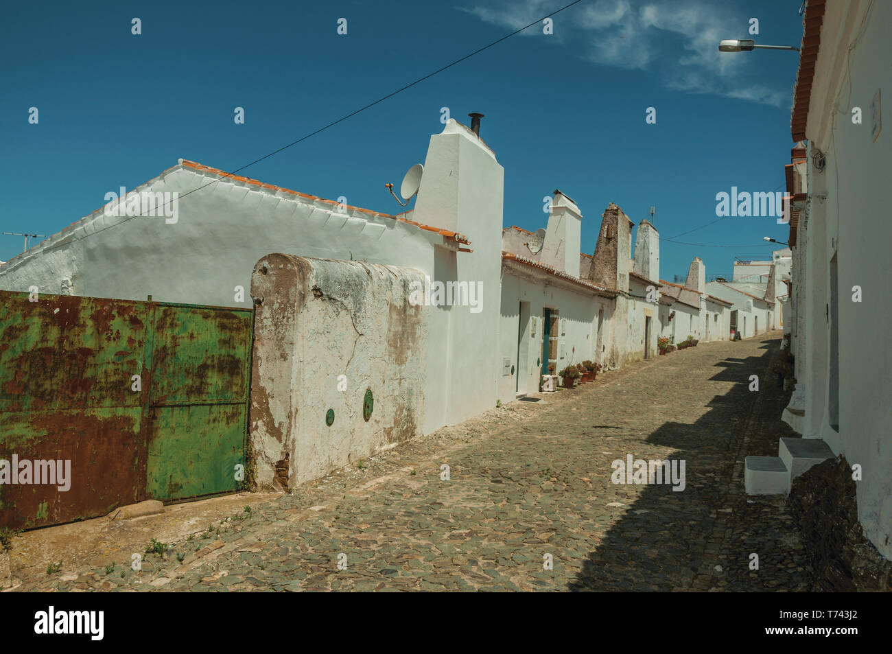 Humble White Wall Houses With Iron Garage Gate In A Sunny Day On A