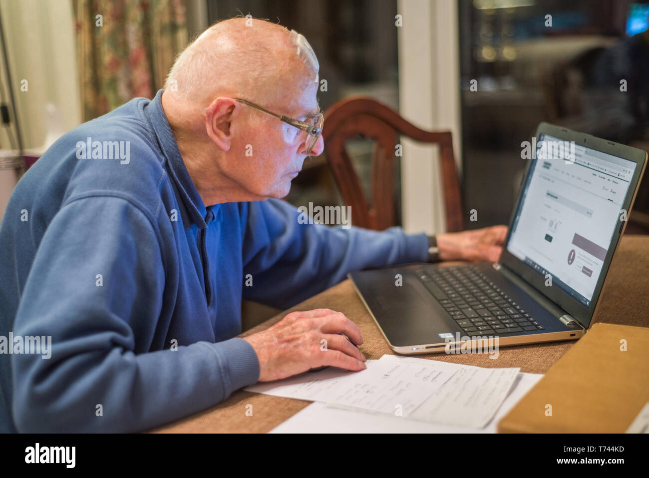 93 year old man having trouble using his computer to check his finances online,very challenging for old people. Stock Photo