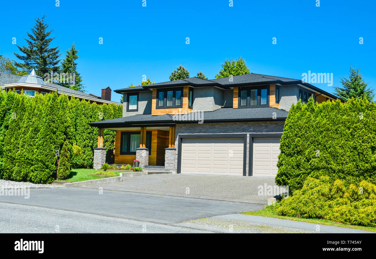 Stylish suburban house with double garage and concrete driveway Stock Photo