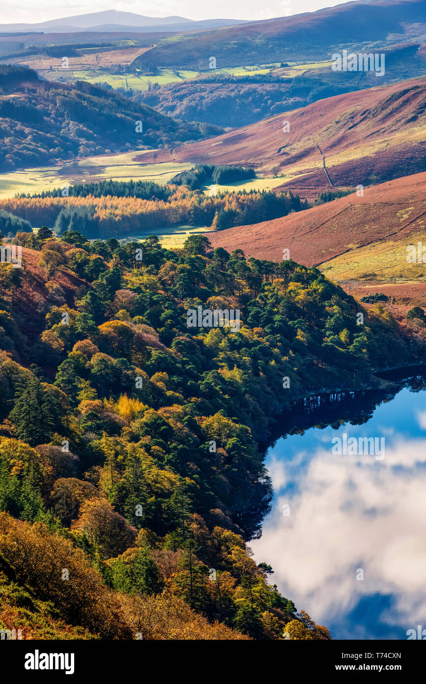 The colourful hills in County Wicklow with the sky reflecting in a tranquil lake; County Wicklow, Ireland Stock Photo