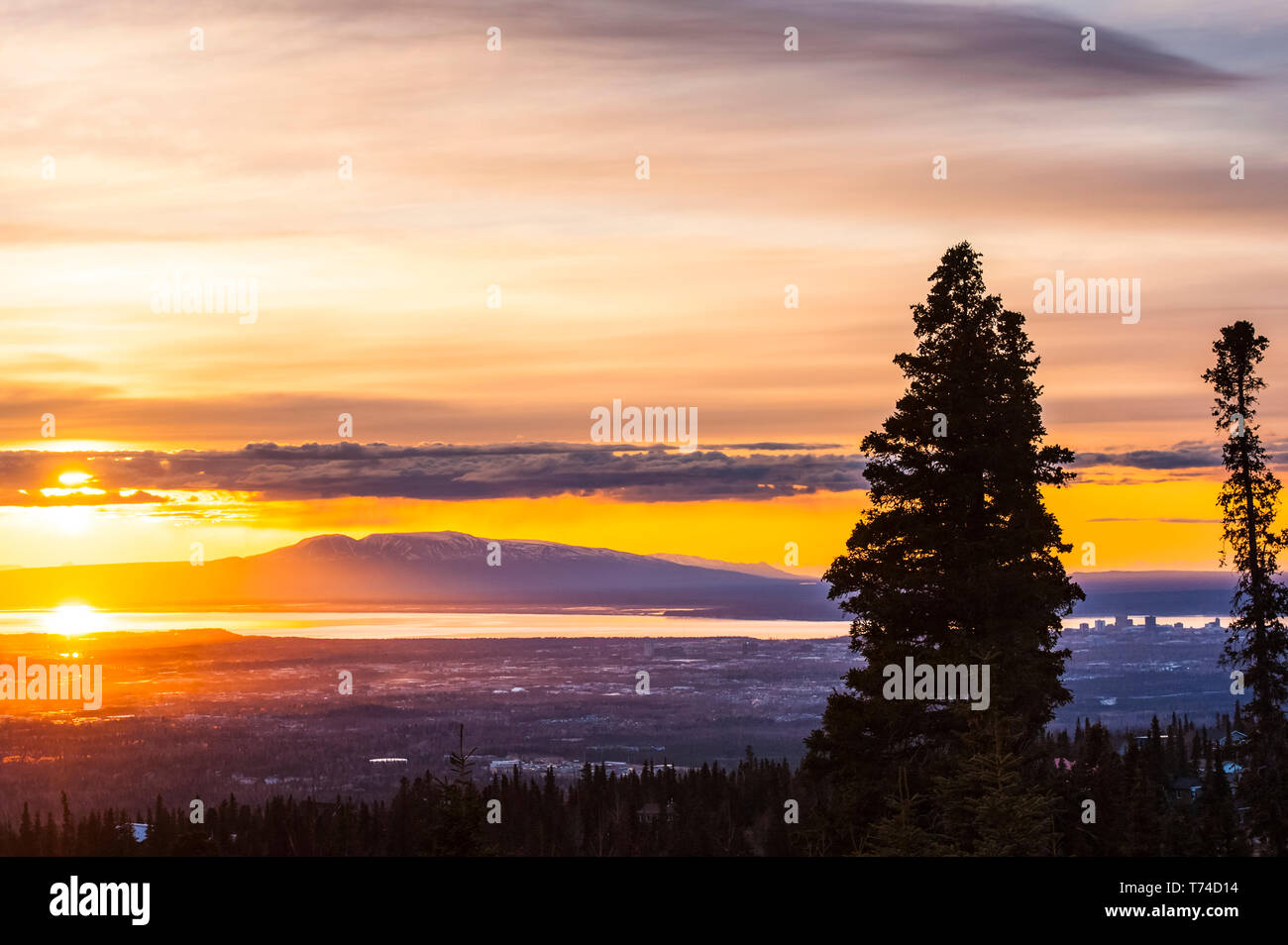 The setting sun over Alaska's Mount Susitna, locally known as 'The Sleeping Lady', with the Cook Inlet and the city of Anchorage in the foreground ... Stock Photo