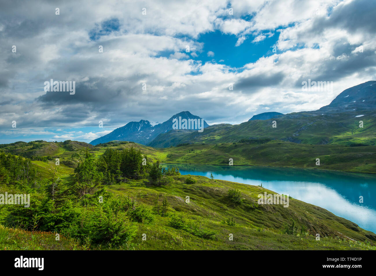 The turquoise water of Lost Lake, a popular hiking and biking destination high in the mountains of the Kenai Peninsula near Seward Stock Photo