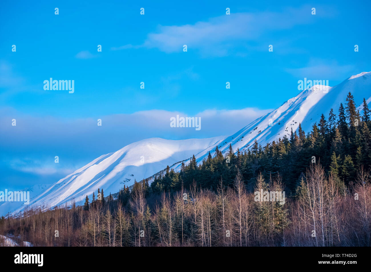 Clouds over mountain tops as daylight fades on the Chugach Mountains in South-central Alaska; Alaska, United States of America Stock Photo