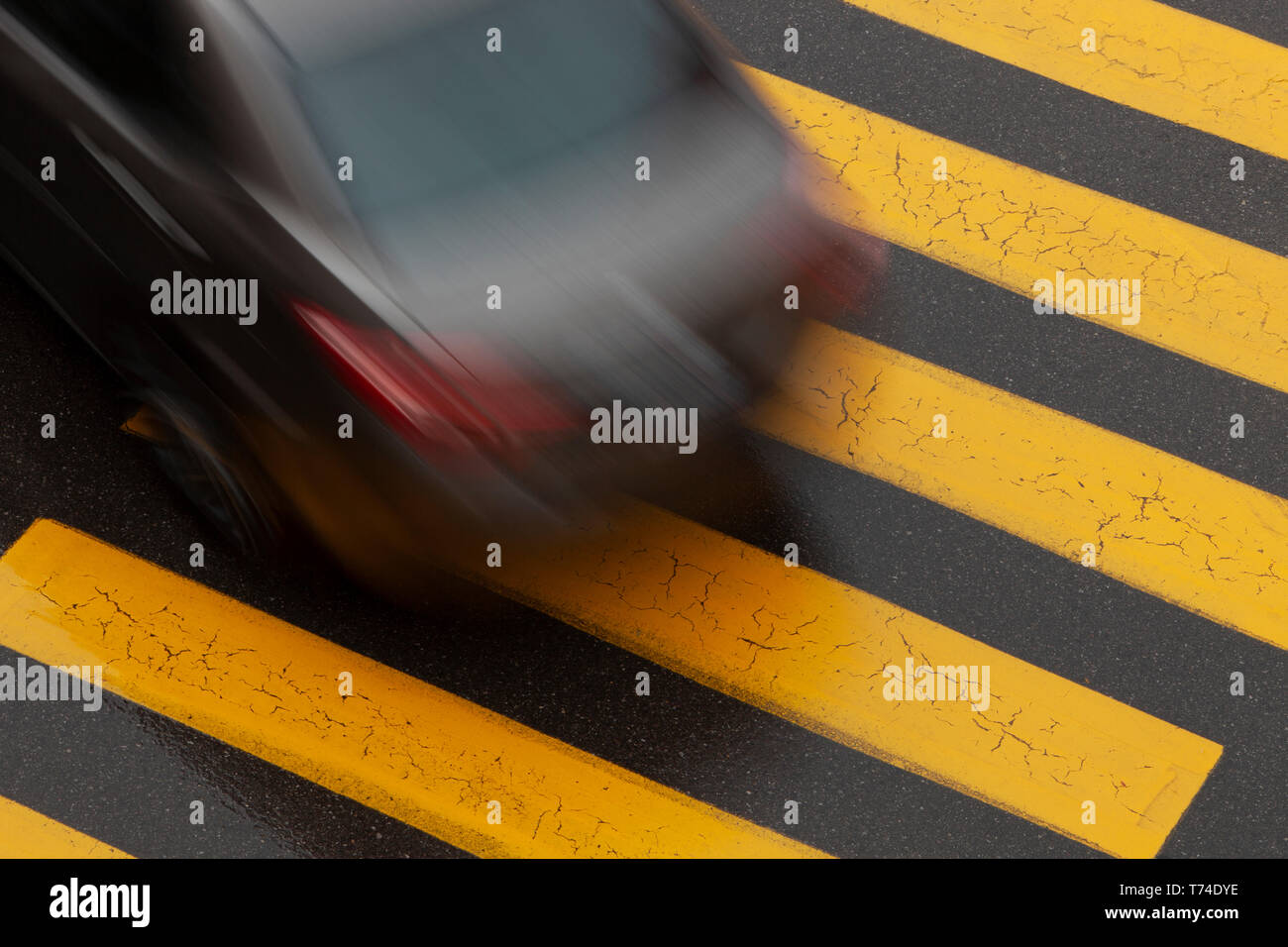 Blurred car over pedestrian crosswalk on a street; Brampton, Ontario, Canada Stock Photo