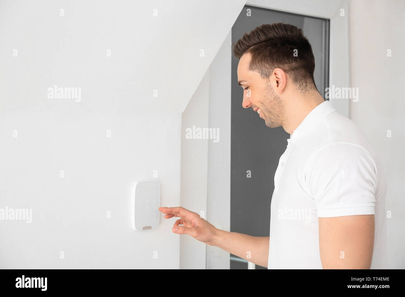 Young man using security system indoors Stock Photo