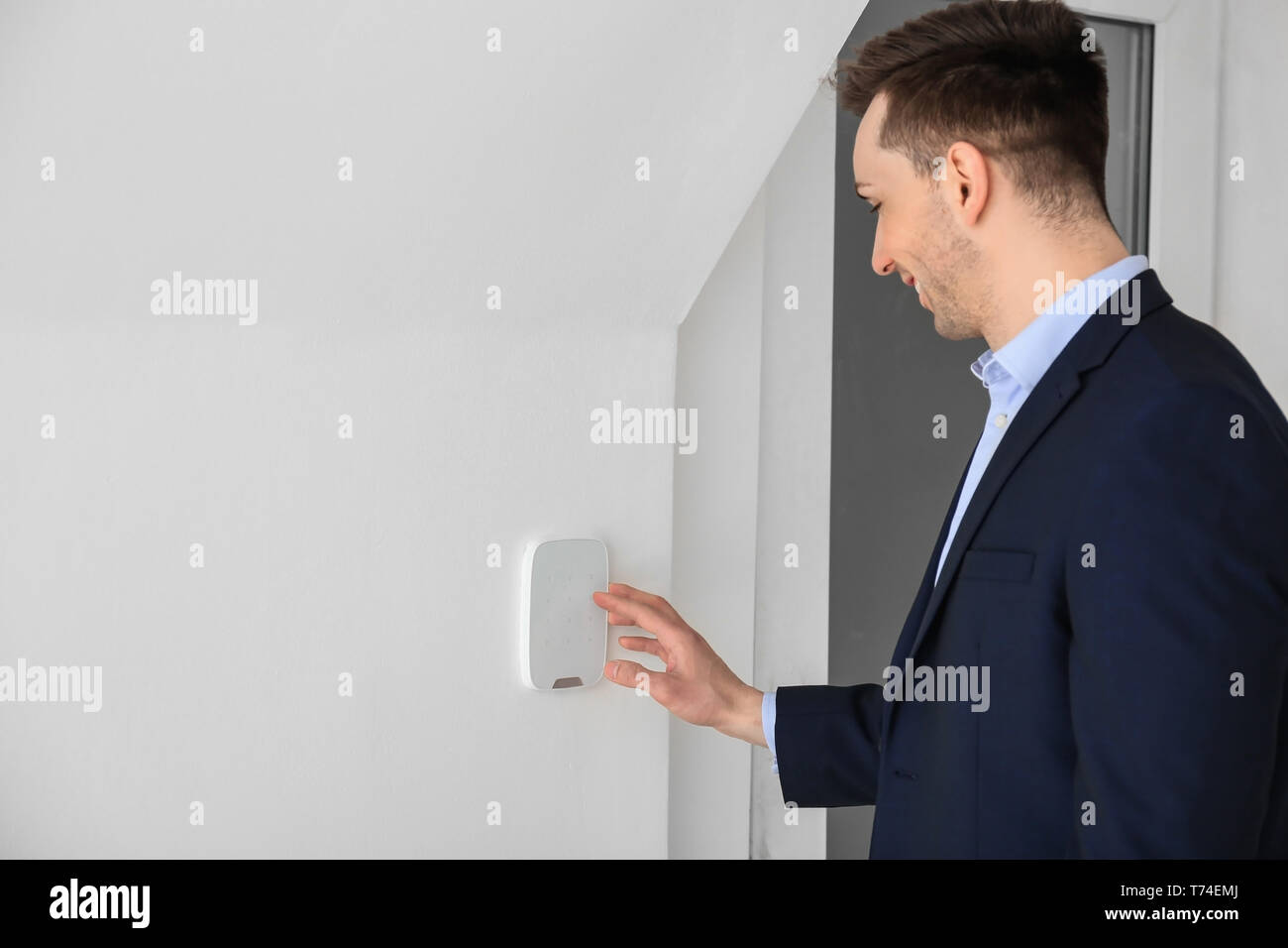 Young man using security system indoors Stock Photo