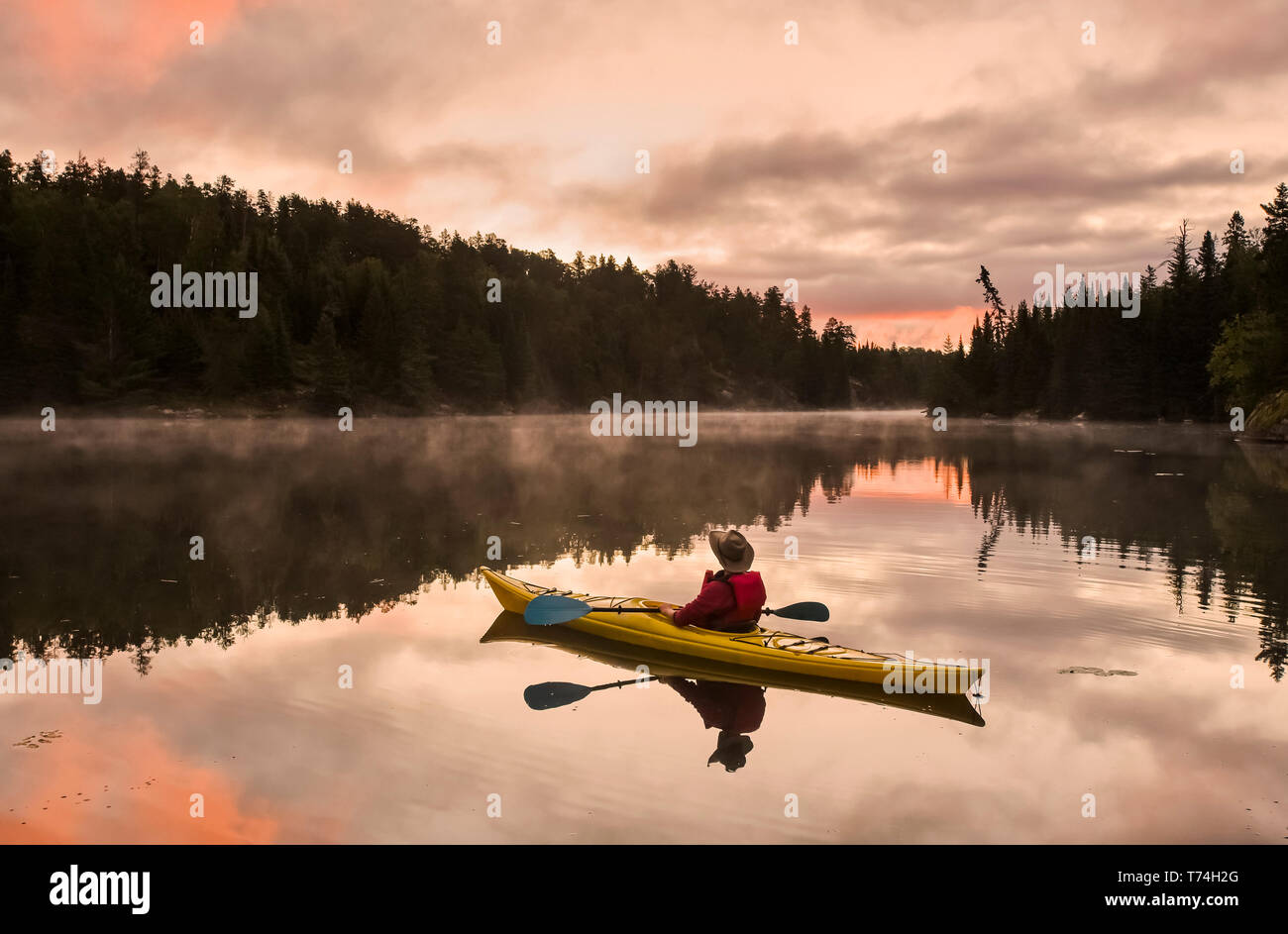 A man kayaking at sunset in the Rushing River, near Kenora; Ontario, Canada Stock Photo