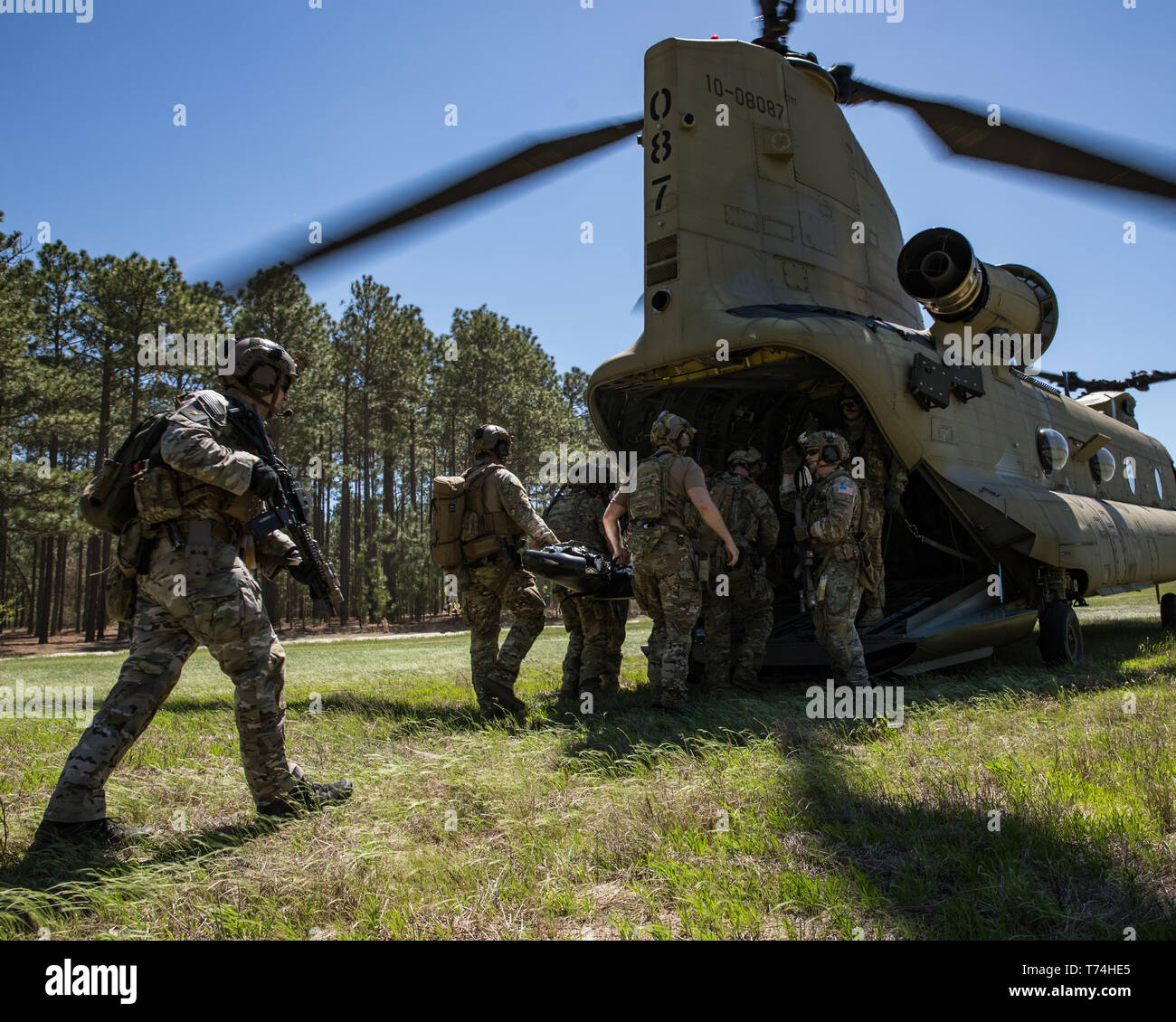 Green Berets assigned to 3rd Special Forces Group (Airborne) enter the back of a CH-47 Chinook helicopter after conducting a raid during a routine training mission April 10, 2019 at Camp Mackal, NC. The Green Berets focused on utilizing new communication systems and casualty care during the training mission. (U.S. Army photo by Sgt. Steven Lewis) Stock Photo
