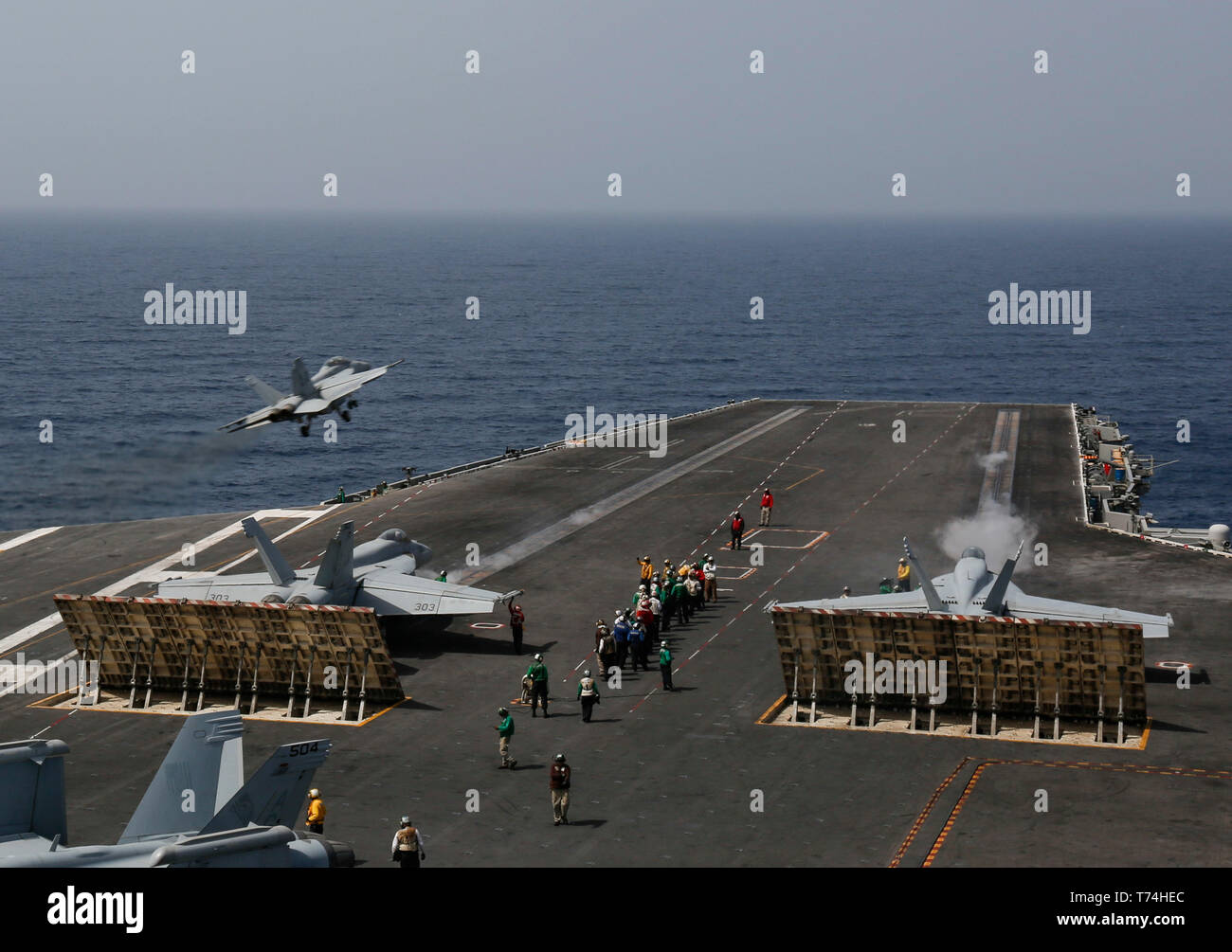 190427-N-MM912-1005  MEDITERRANEAN SEA  Two F/A-18E Super Hornets from the 'Freedom Fighters' of Carrier Air Wing (CVW) 7 prepare to launch from the flight deck of the Nimitz-class aircraft carrier USS Abraham Lincoln (CVN 72) as an F/A-18F Super Hornet from the 'Jolly Rogers' of Strike Fighter Squadron (VFA) 103 launches from the flight deck. Abraham Lincoln is deployed as part of the Abraham Lincoln Carrier Strike Group (ABECSG) in support of maritime security cooperation efforts in the U.S. 5th, U.S. 6th and U.S. 7th Fleet areas of operation. With Abraham Lincoln as the flagship, deployed s Stock Photo