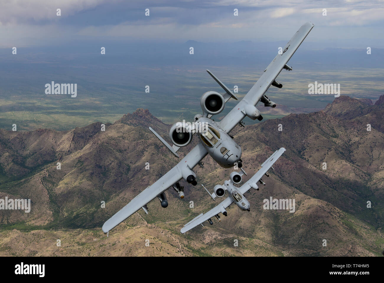 Two A-10C Thunderbolt IIs fly in formation over southern Arizona, April 29, 2019.  The A-10 is built around the GAU-8 Avenger 30MM Gatling gun and is capable of carrying an additional 16,000 pounds of munitions under the wings and belly of the aircraft. (U.S. Air Force photo by Staff Sgt. Betty R. Chevalier) Stock Photo