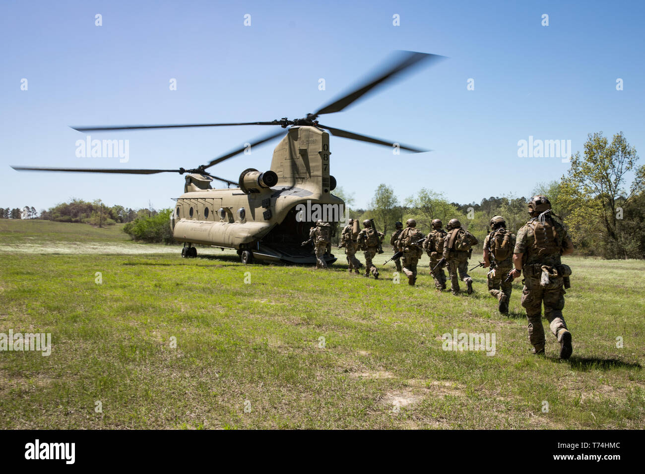 Green Berets assigned to 3rd Special Forces Group (Airborne) enter the back of a CH-47 Chinook helicopter after conducting a raid during a routine training mission April 10, 2019 at Camp Mackal, NC. The Green Berets focused on utilizing new communication systems and casualty care during the training mission. (U.S. Army Photo by Sgt. Steven Lewis) Stock Photo