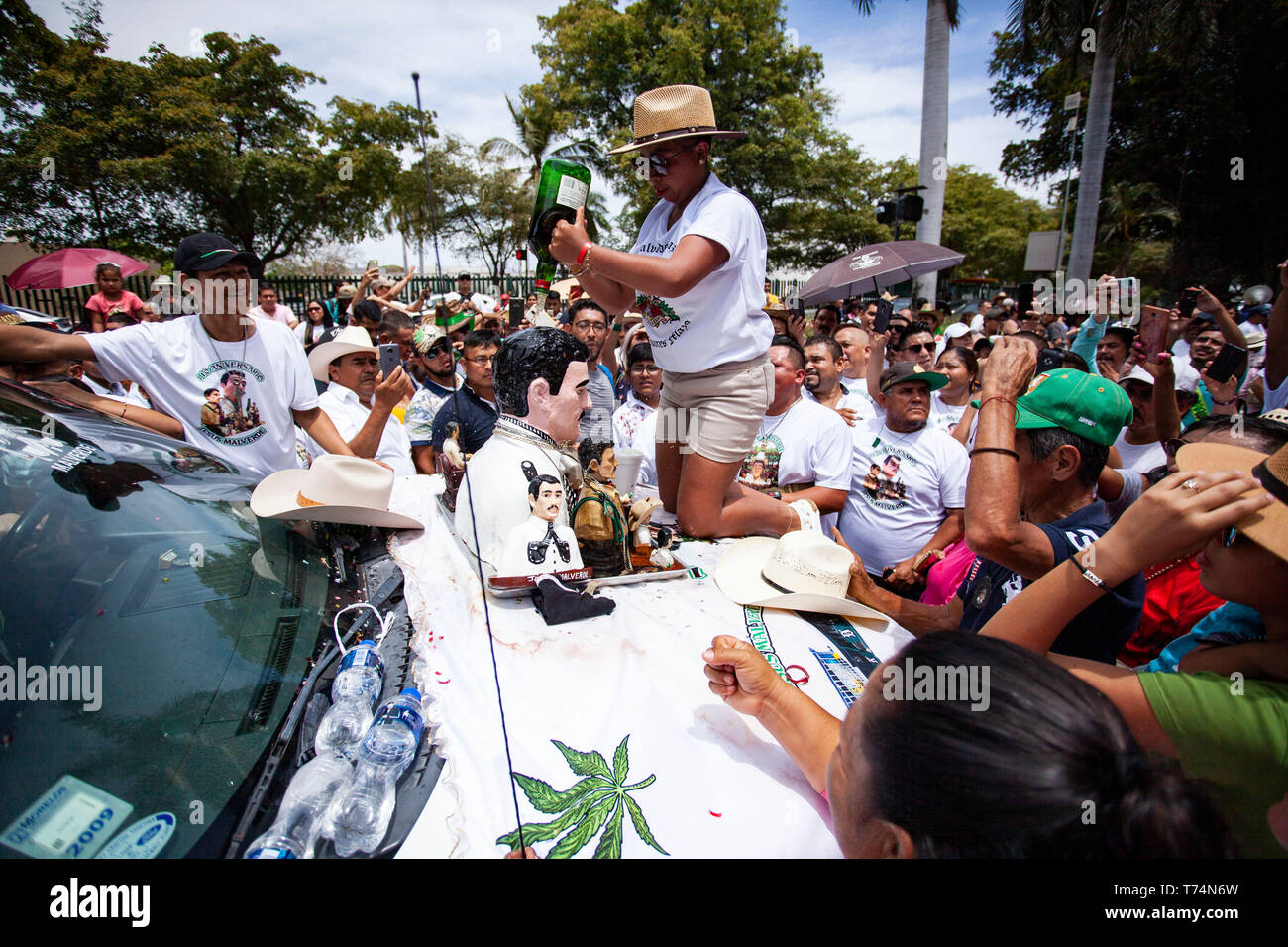Culiacan, Mexico. 03rd May, 2019. Believers pour whisky over the bust of Jesus Malverde, who is considered a saint of drug bosses in Mexico. On the occasion of his 110th anniversary of death on 03.05.2019 numerous faithful gathered in his native town in the federal state of Sinaloa. Malverde, who is not recognized as a saint by the Catholic Church, is said to have been a highwayman during his lifetime. Many Mexicans worship him as a kind of Robin Hood. According to oral tradition, he robbed the rich families in the Sinaloa region and then distributed the booty among the poor. Credit: dpa pictu Stock Photo