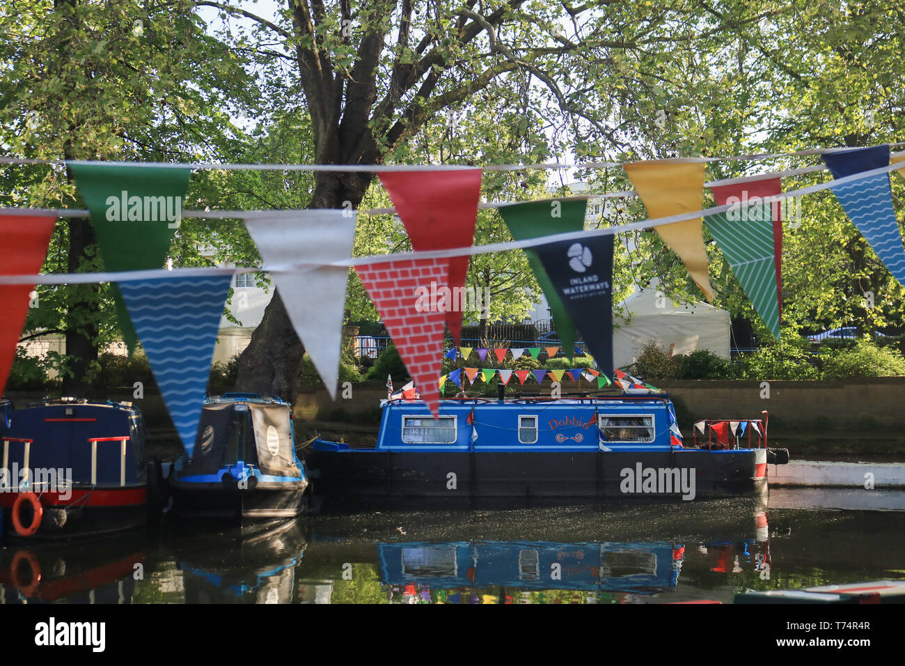 London, UK. 4th May, 2019. Colourful bunting on Canal barges at the start of The Inland Waterways Association's annual pageant of canal boats at the Canalway Cavalcade festival in Little Venice, West London on May bank holiday weekend. Credit: amer ghazzal/Alamy Live News Stock Photo