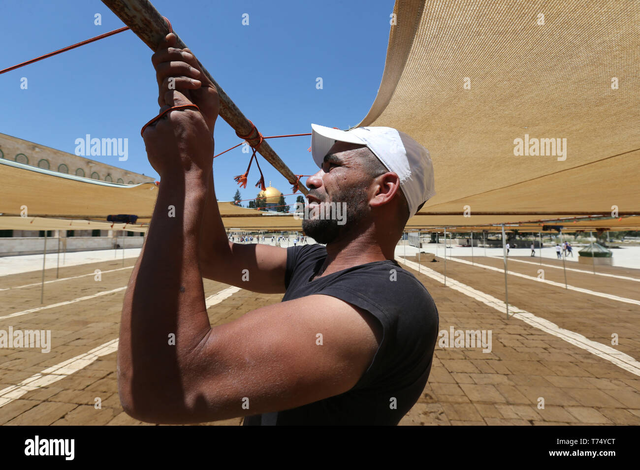 Jerusalem, Jerusalem's Old City. 4th May, 2019. A worker puts up canvases to provide shade for worshippers on the sacred compound known to Muslims as the Noble Sanctuary and to Jews as the Temple Mount, in preparation for the holy Muslim month of Ramadan, in Jerusalem's Old City, May 4, 2019. Credit: Muammar Awad/Xinhua/Alamy Live News Stock Photo