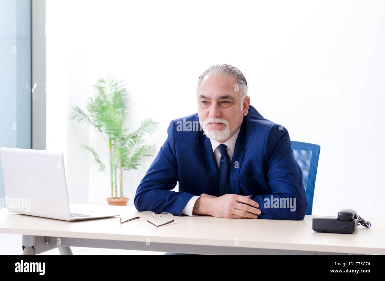 Aged businessman doing yoga exercises in the office Stock Photo - Alamy