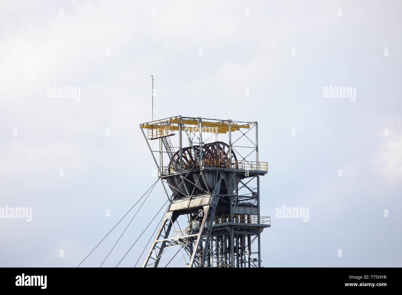 Coal mine headgear cage. Metal construction on gray sky background. Industrial landscape. Colliery Silesia, Poland. Stock Photo