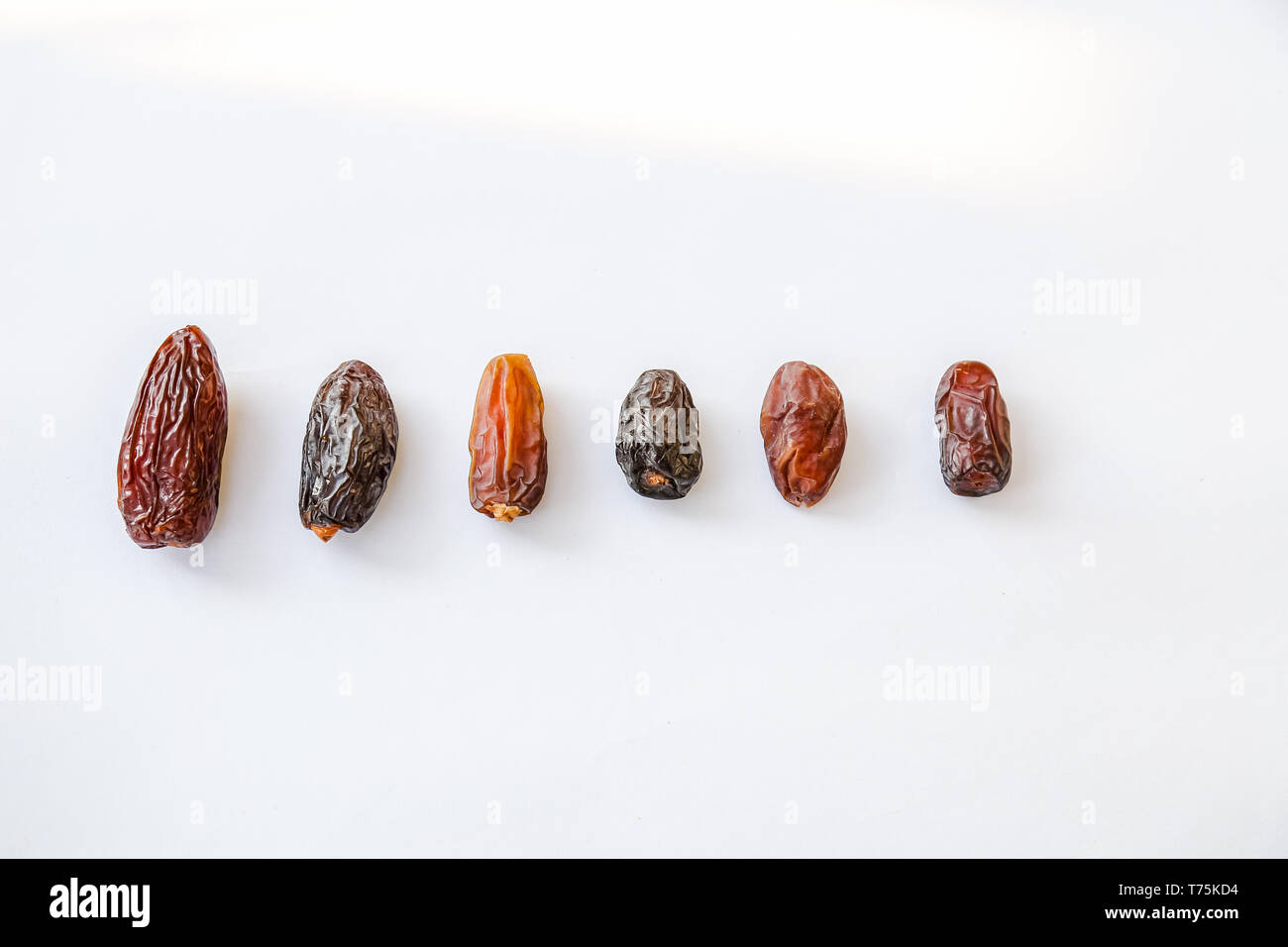 Different types of sizing dates namely from the left as King or Golden Medjool, Black Medjool, Mabroom, Ajwa, Deglet Nour and Piarom Malik Stock Photo
