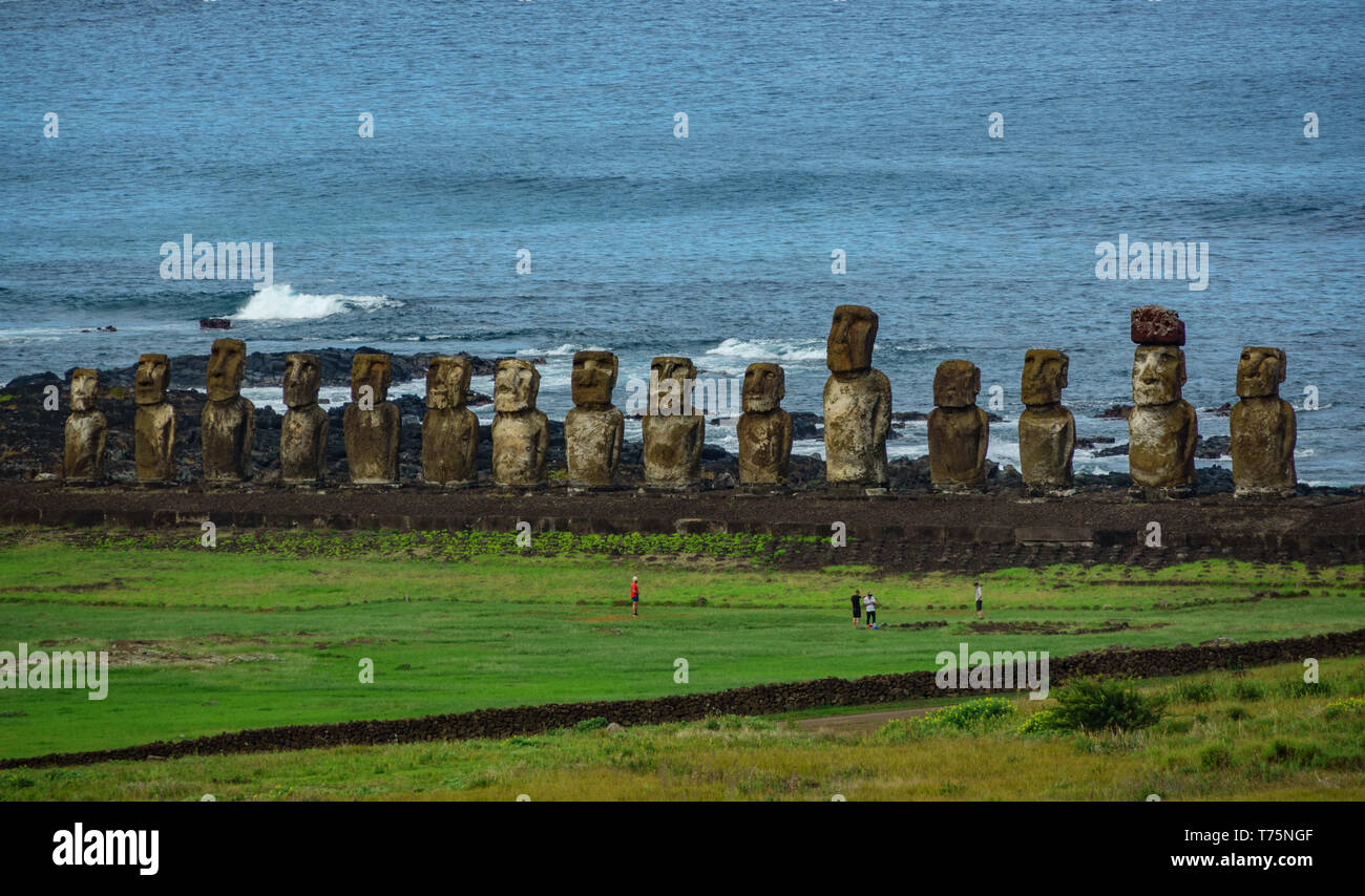 Moai statues on Easter Island with tourists from the distance. Ahu