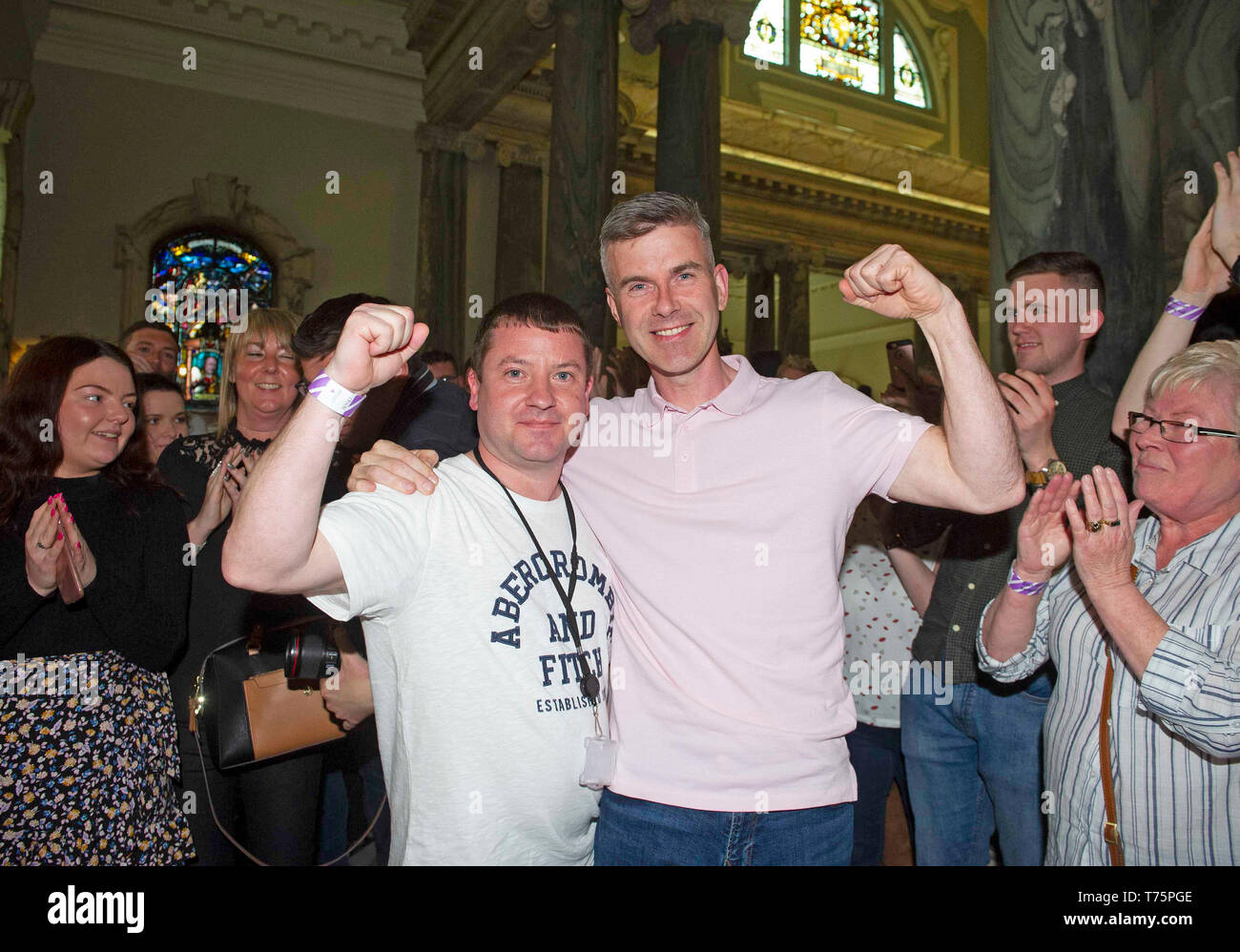 Sinn Fein candidates for the Black Mountain area Ciaran Beattie (left) and Stephen Corr (right) celebrate during the local government election count at Belfast City Hall. Stock Photo