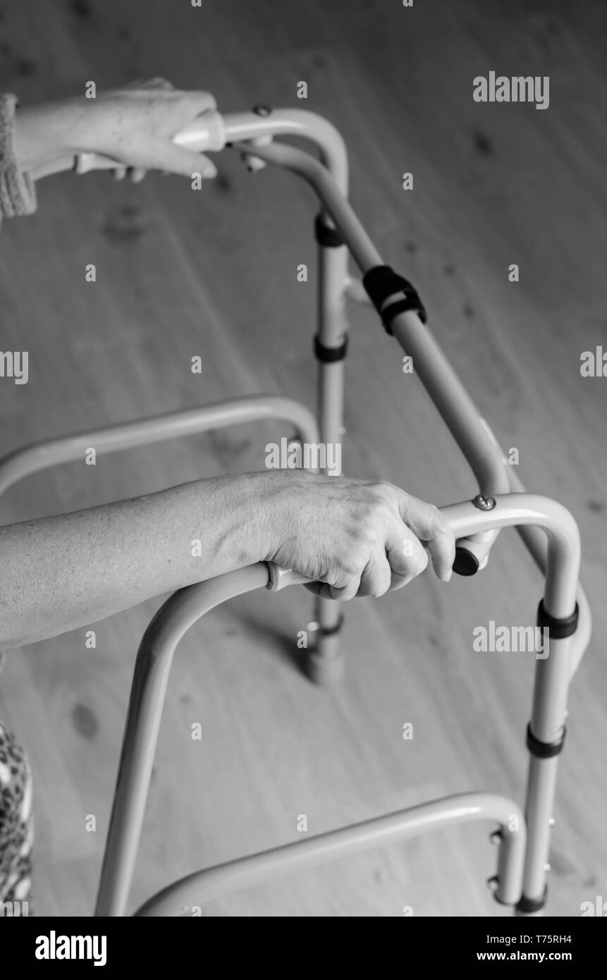 Hands of a senior woman on the handles of a walker. Rehabilitation and healthcare concept. Stock Photo