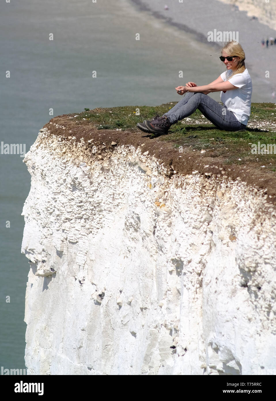 Tourists risking their lives to get selfies on 400 foot crumbling chalk cliffs, Birling Gap, East Sussex, UK Stock Photo