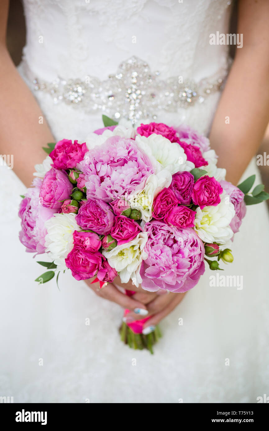 Unrecognizable bride holding a refined wedding bouquet of pink roses ...