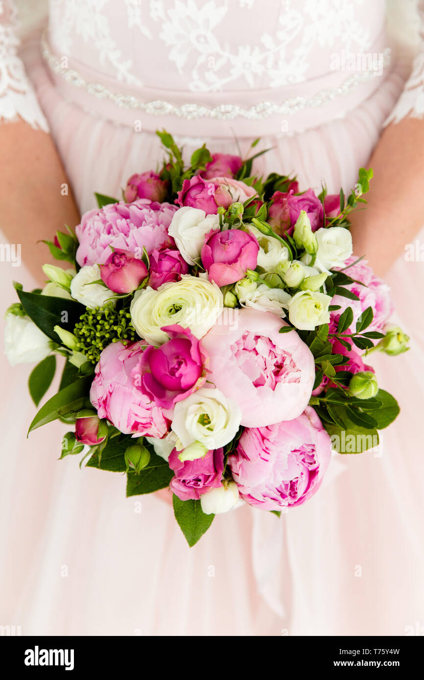 Unrecognizable bride holding a refined wedding bouquet of pink roses ...