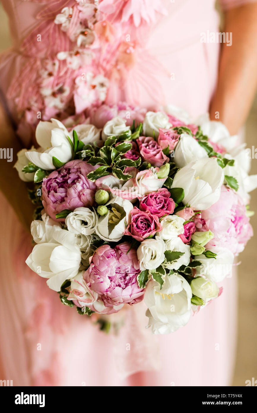 Unrecognizable bride holding a refined wedding bouquet of pink roses ...