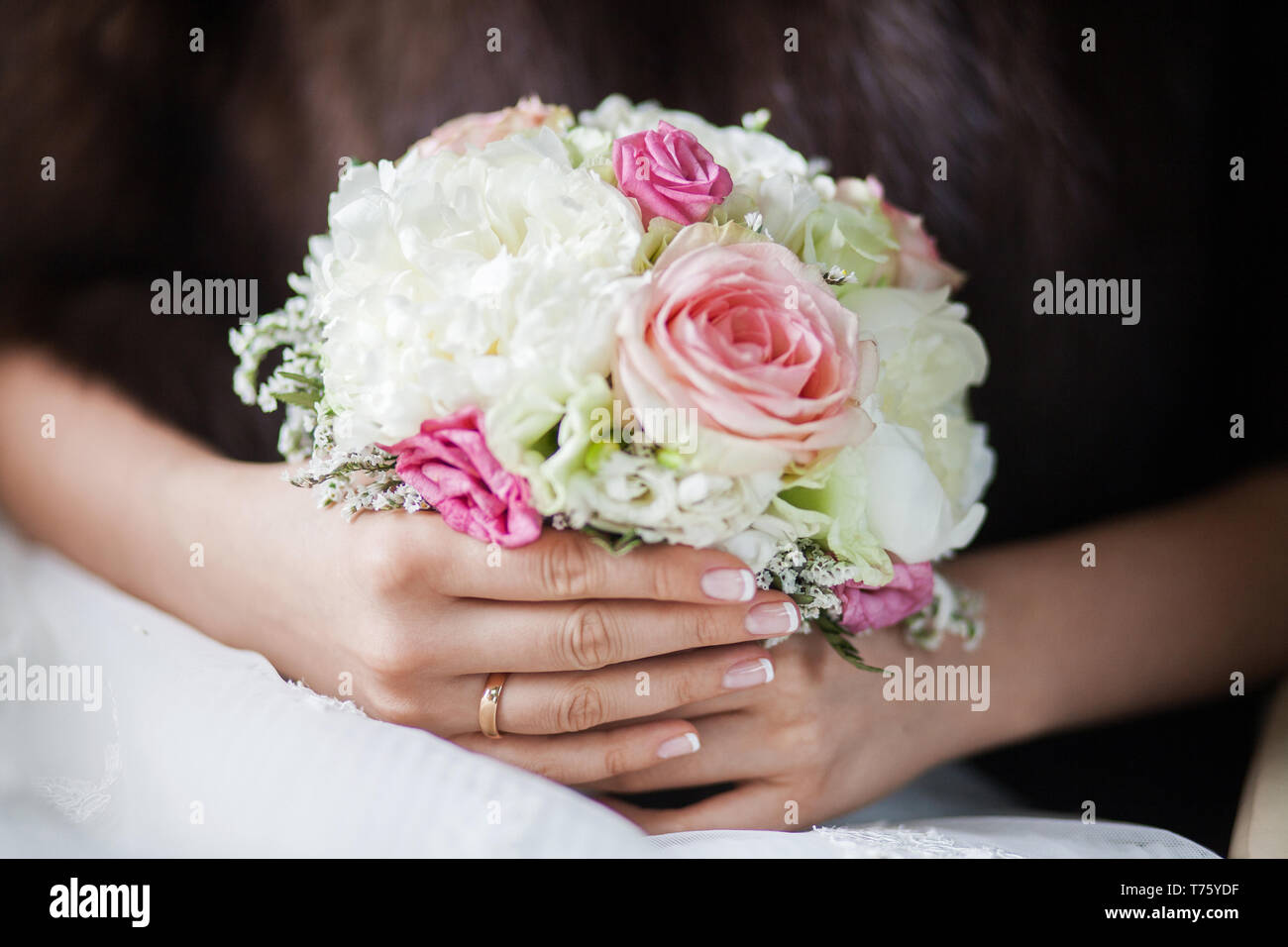 Beautiful bridal bouquet of peonies and pink roses in the hands of an ...