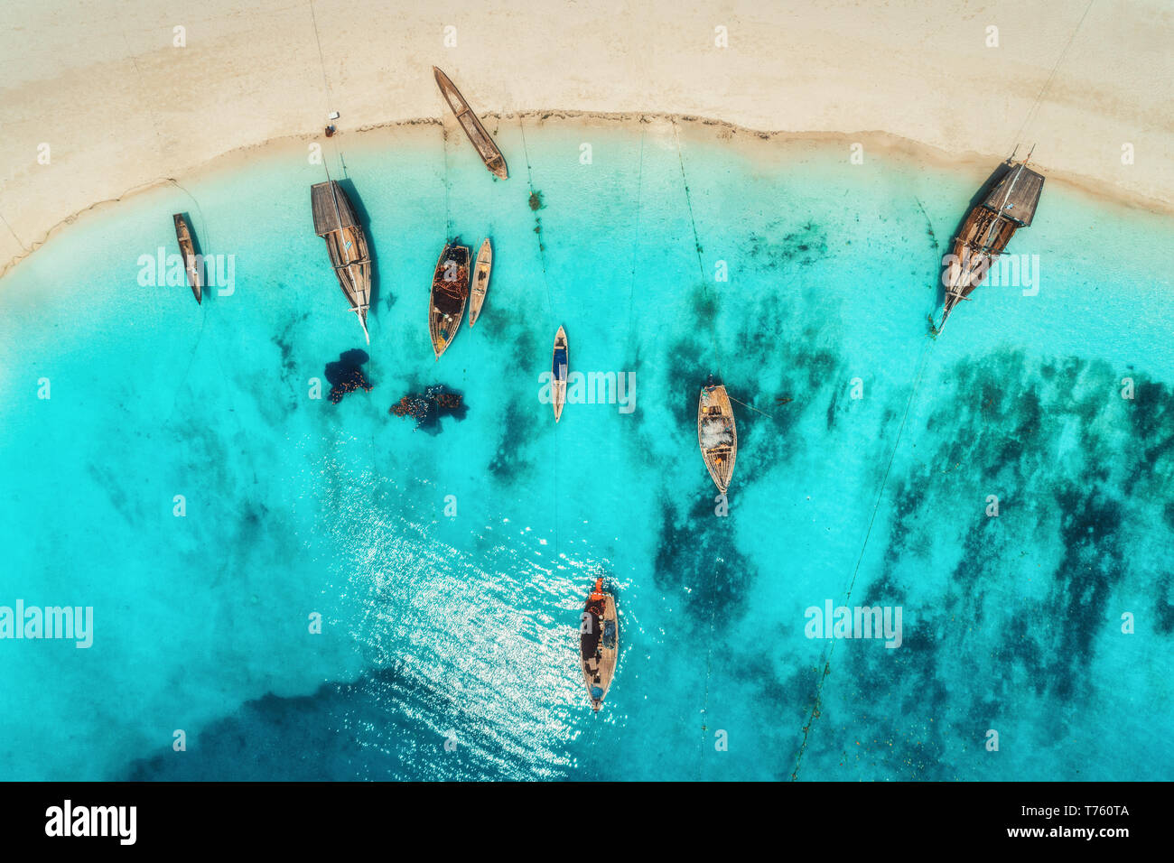 Aerial view of the fishing boats in clear blue water at sunset in ...