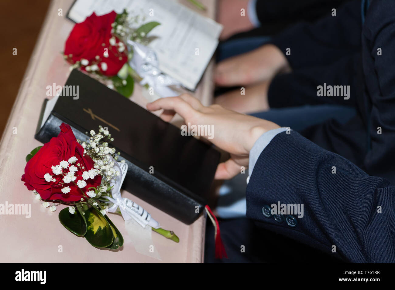 A picture of the Holy Bible with red roses in church Stock Photo