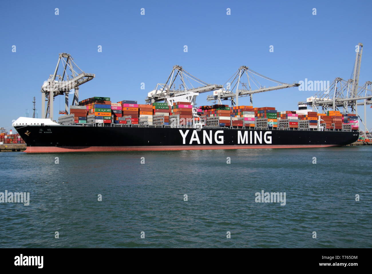The container ship YM Wisdom will be loaded and unloaded in the port of Rotterdam on April 10, 2019. Stock Photo