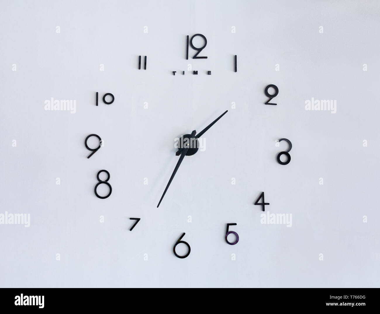 Artistic handmade clock on a grey wall Stock Photo